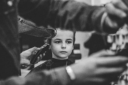 grayscale photo of a boy having hair cut thumbnail