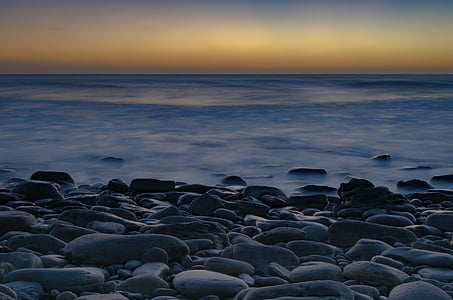 gray stones on shore near beach during golden hour thumbnail