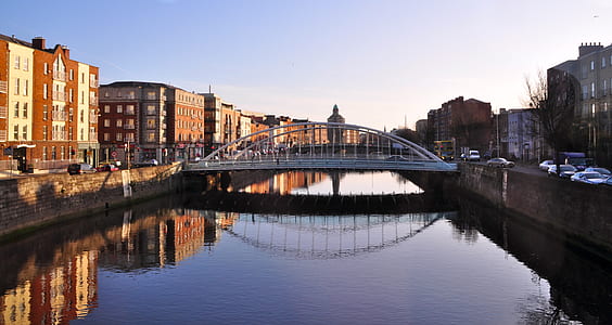 gray metal bridge on canal beside buildings thumbnail
