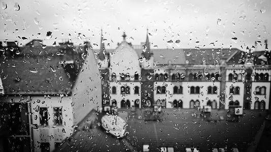 greyscale photo of buildings during rainy day thumbnail