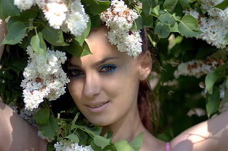 woman wearing pink spaghetti strap top standing on white petaled flowers thumbnail