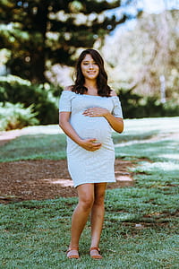 pregnant woman standing on grass field thumbnail