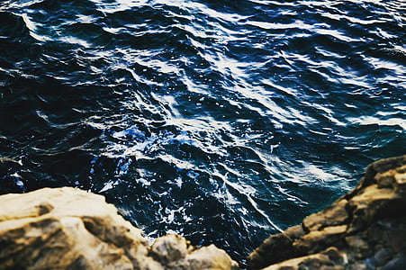 body of water beside brown rock thumbnail