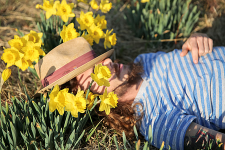 A man wearing a hat lying down amongst flowers thumbnail