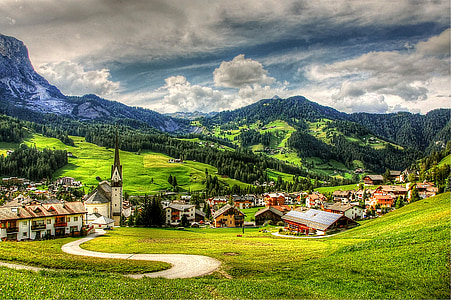 houses on fields surrounded with mountains thumbnail