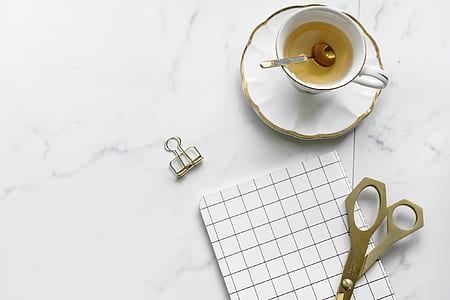 teacup on table beside scissors thumbnail