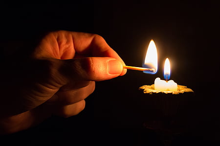 person lighted candle using match stick thumbnail