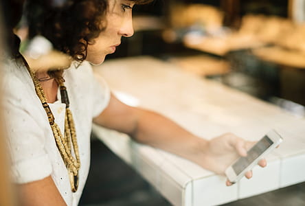 woman holding white Android smartphone thumbnail