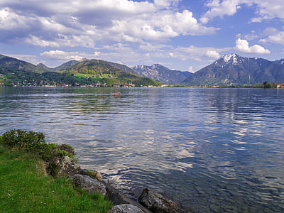 grass field beside calm body of water thumbnail