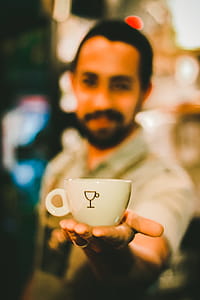 Focus Photography of Man Holding Ceramic Teacup thumbnail
