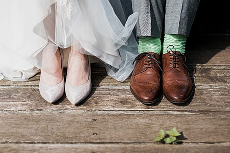 two pairs of men's brown leather dress shoes and women's gray almond-toe shoes on foot thumbnail