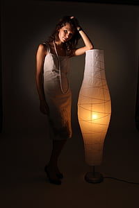 woman wearing grey spaghetti-strap dress standing with paper rice floor lamp thumbnail
