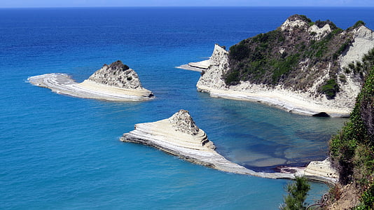 island with trees under blue skies daytime thumbnail