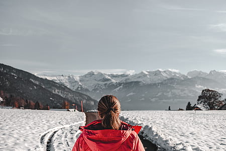 woman wearing red hoodie jacket standing in front of mountain thumbnail