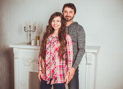 man and woman taking selfie near white brick wall thumbnail