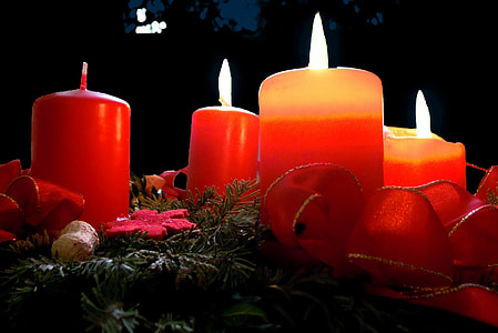 four lighted red pillar candles thumbnail