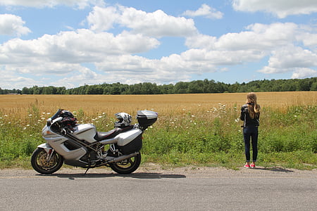 woman standing beside motorcycle thumbnail