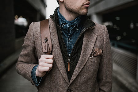 man standing near gray wall thumbnail