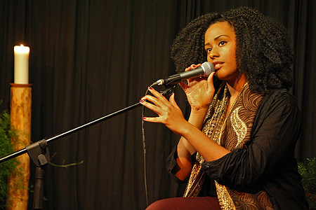 woman holding black microphone with stand thumbnail