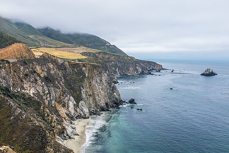 aerial view photography of rock formation beside body of water at daytime thumbnail