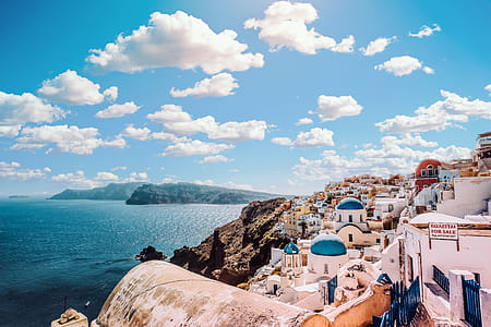 White Concrete House Near Body of Water Under White and Blue Cloudy Sky thumbnail