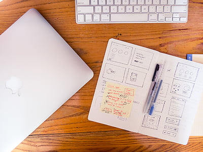silver MacBook on brown wooden table thumbnail