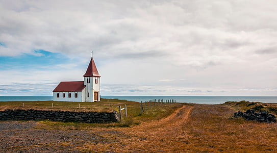 white and brown house near body of water under white cloudy sky thumbnail
