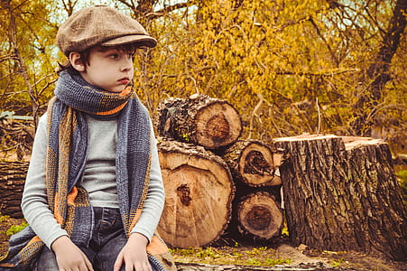 boy sitting on brown tree log thumbnail