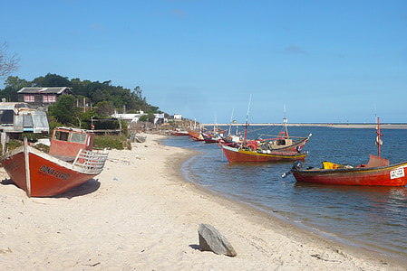 three red boats on seashores at daytime thumbnail