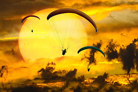 three person parachute against sun thumbnail