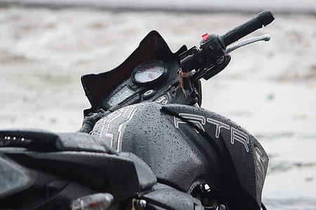 close-up photo of black RTR sports bike with water dew thumbnail