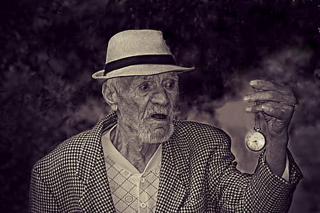 Man Holding Pocket Watch in Grayscale thumbnail