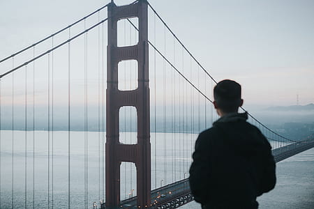 man looking at bridge during daytime thumbnail