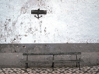 empty brown bench beside white and gray wall thumbnail