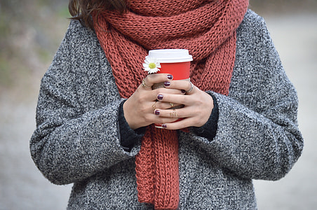 woman wearing gray jacket with brown scarf holding red and white cup thumbnail