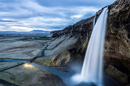 brown rock formation with waterfalls during daytime thumbnail