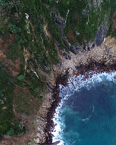 bird's-eye view photo of waves crashing on sand thumbnail