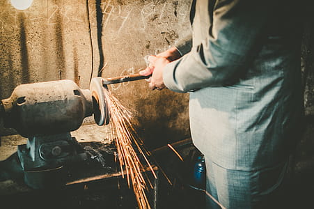 Person Grinding Metal on Bench Grinder thumbnail