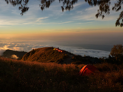 orange camping tent on hill with sea of clouds background thumbnail