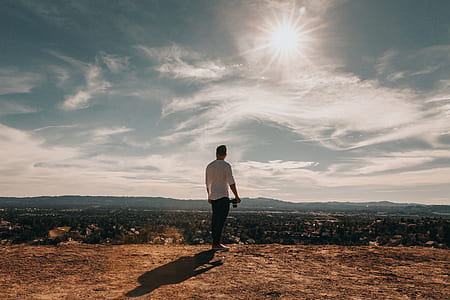 standing man holding camera looking upward thumbnail