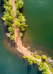 high angle photo of land pathway between body of water thumbnail