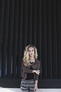 woman wearing brown cardigan beside metal wall thumbnail