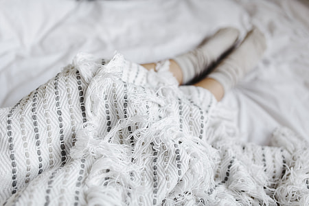 Soft photo of woman on the bed with the book and cup of coffee in hands thumbnail