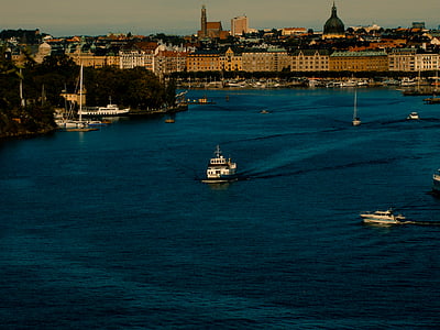 sailboat and speedboat on body of water thumbnail
