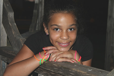 girl sitting on wooden bench smiling thumbnail