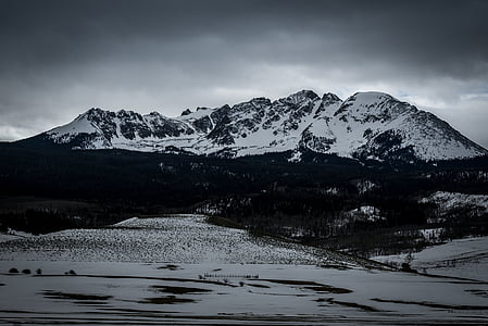 mountain covered in snow under gray clouds thumbnail