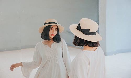 Woman Wearing White Long-sleeved Dress and Beige Sun Hat thumbnail