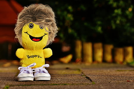 selective focus photography of yellow plush toy on ground thumbnail