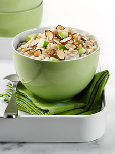 round green ceramic bowl of cooked food beside silver spoon thumbnail