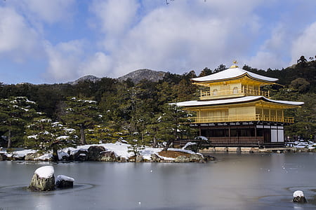 Temple Near Body Of Water Surrounded By Trees With Mountain Background thumbnail